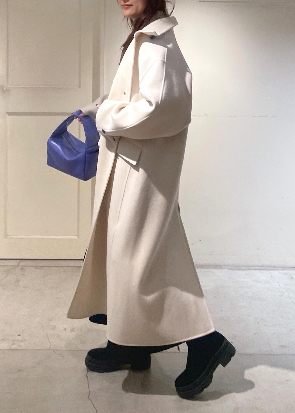 ホワイト系のその他アウター、パープル系のハンドバッグ、ホワイト系のニット/セーターを着用したレディースの冬コーディネートの2枚目の写真