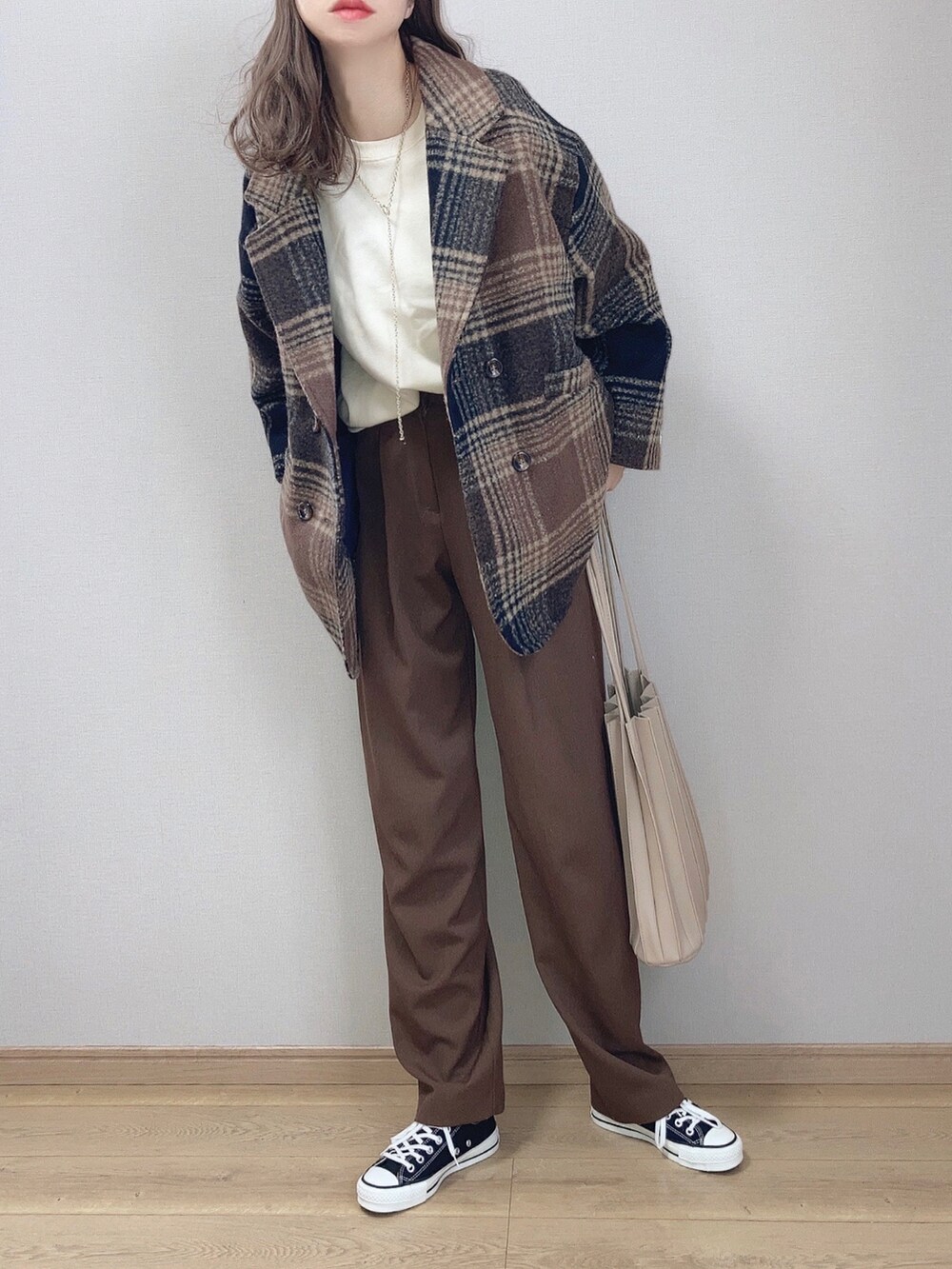 ホワイト系のスウェット、ブラウン系のその他パンツ、ベージュ系のスニーカーを着用したレディースの冬コーディネートの3枚目の写真