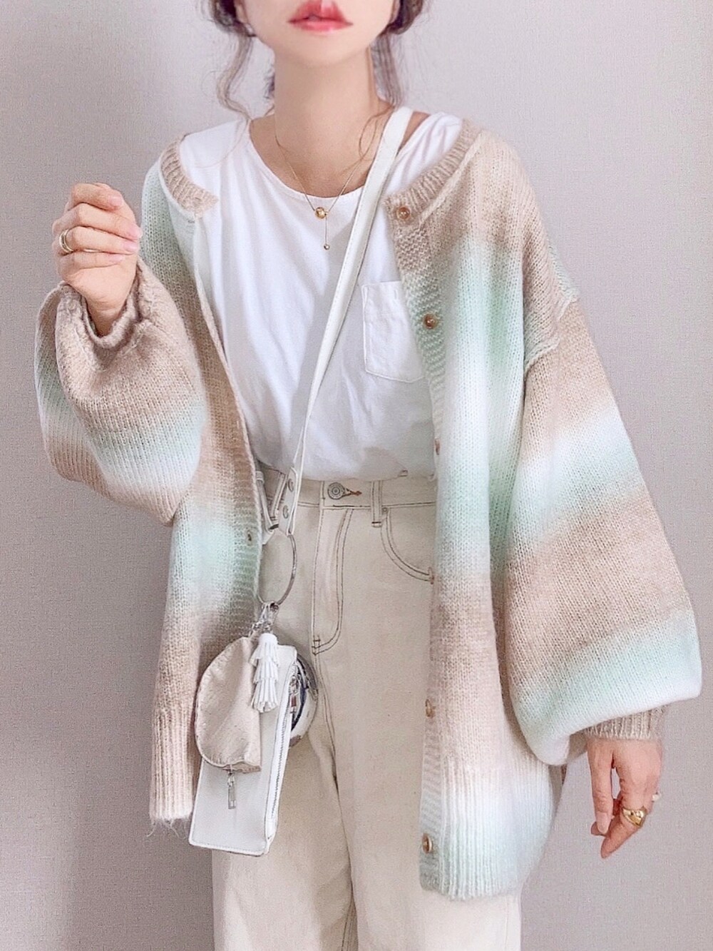 グリーン系のカーディガン/ボレロ、ベージュ系のデニムパンツ、ブラウン系のローファーを着用したレディースの秋コーディネートの4枚目の写真