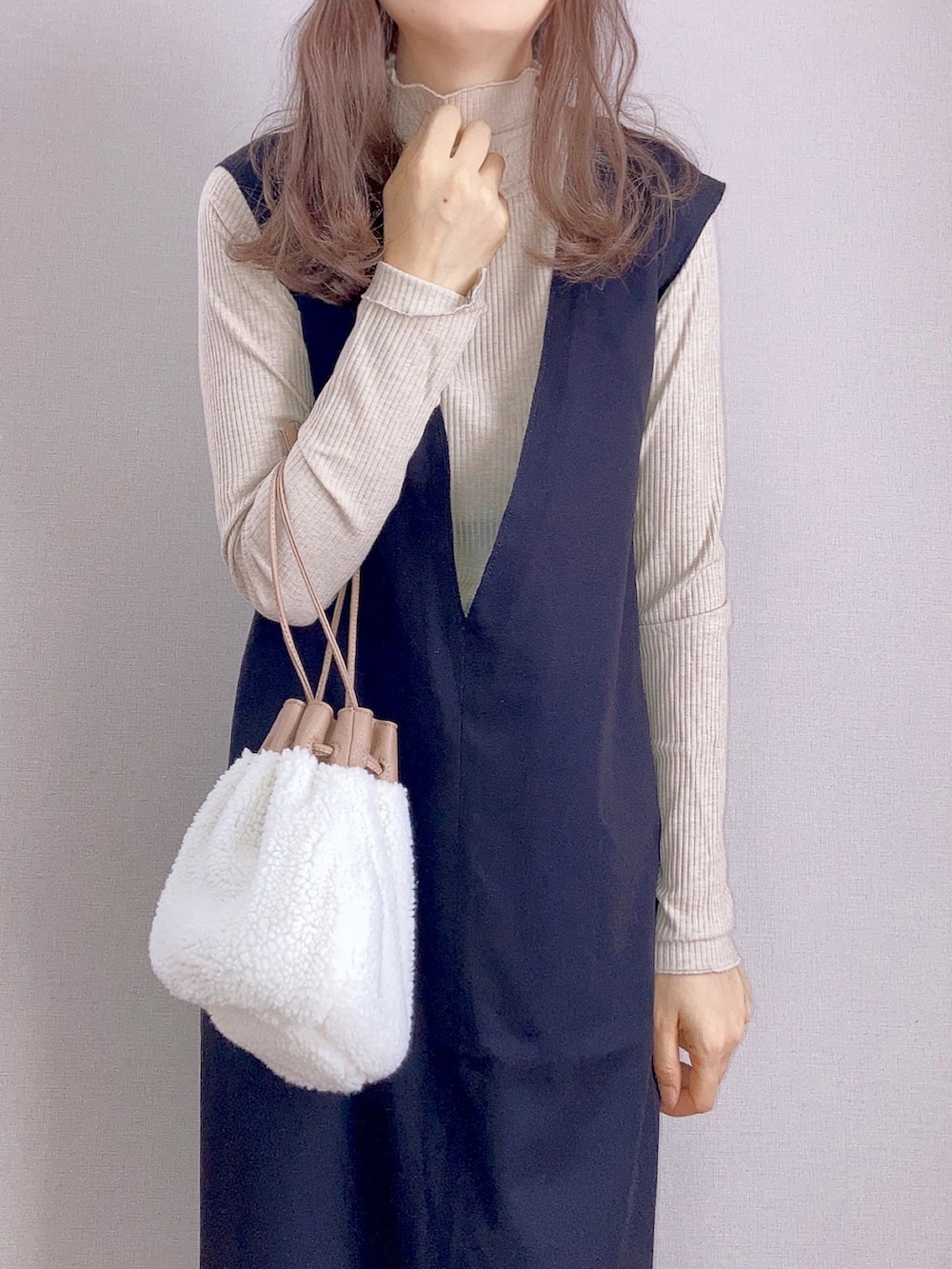 ベージュ系のTシャツ/カットソー、ブラック系のワンピース、ベージュ系のハンドバッグを着用したレディースの秋コーディネートの3枚目の写真