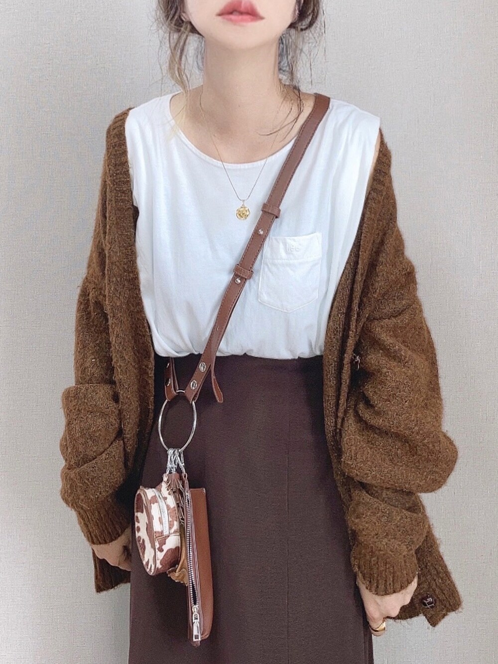 ブラウン系のスカート、ブラウン系のショルダーバッグ、ブラウン系のカーディガン/ボレロを着用したレディースの秋コーディネートの4枚目の写真