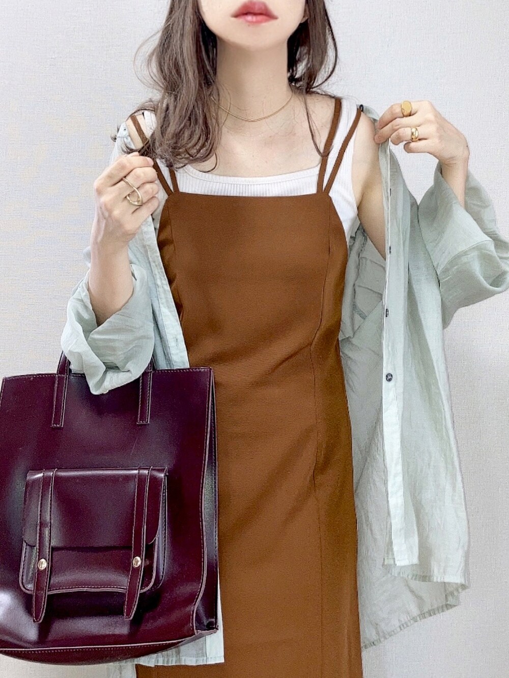 ブラウン系のワンピース、グリーン系のシャツ/ブラウス、ホワイト系のタンクトップを着用したレディースの夏コーディネートの2枚目の写真