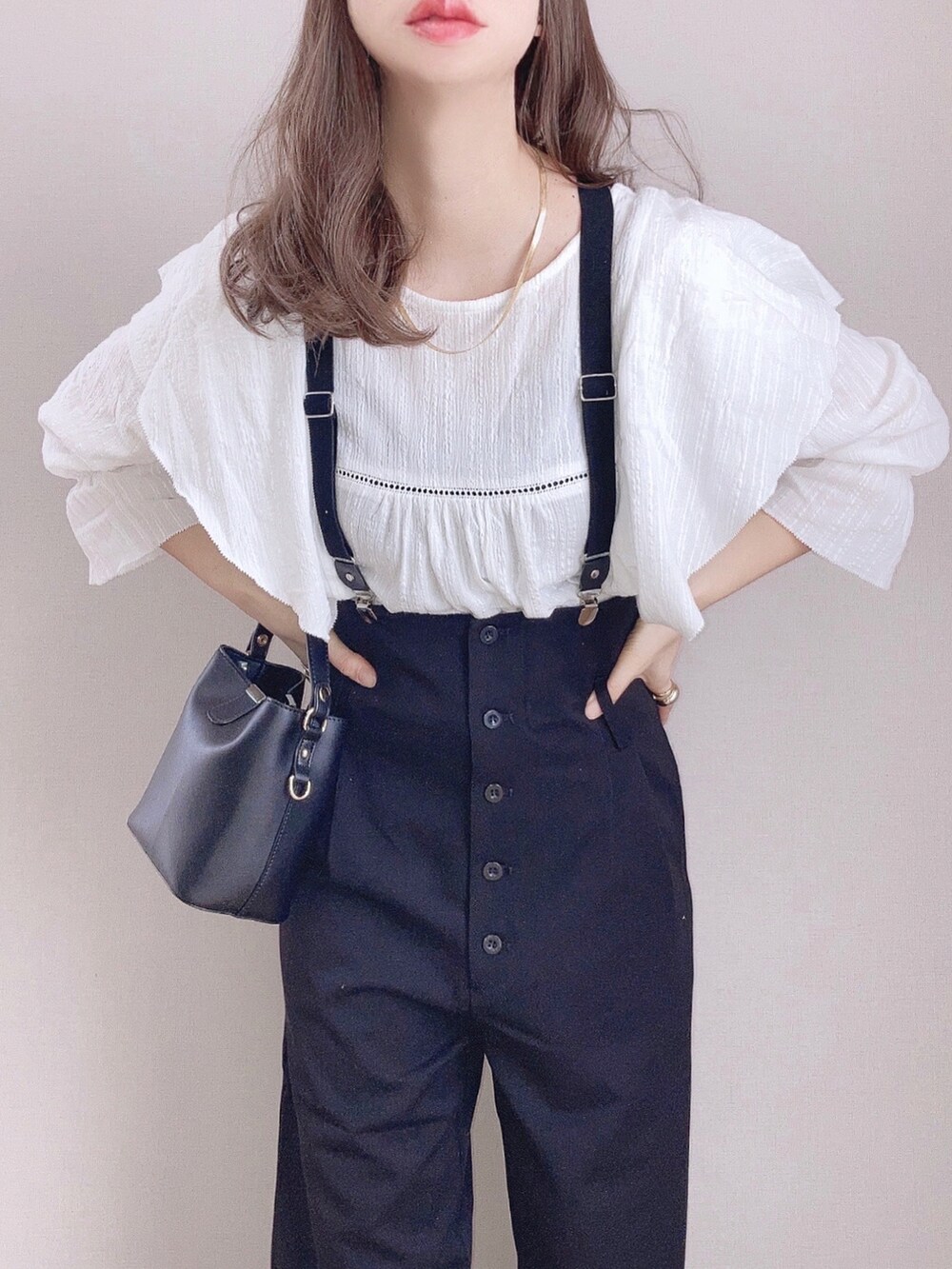 ホワイト系のシャツ/ブラウス、ブラック系のサロペット/オーバーオール、ブラック系のショルダーバッグを着用したレディースの冬コーディネートの3枚目の写真