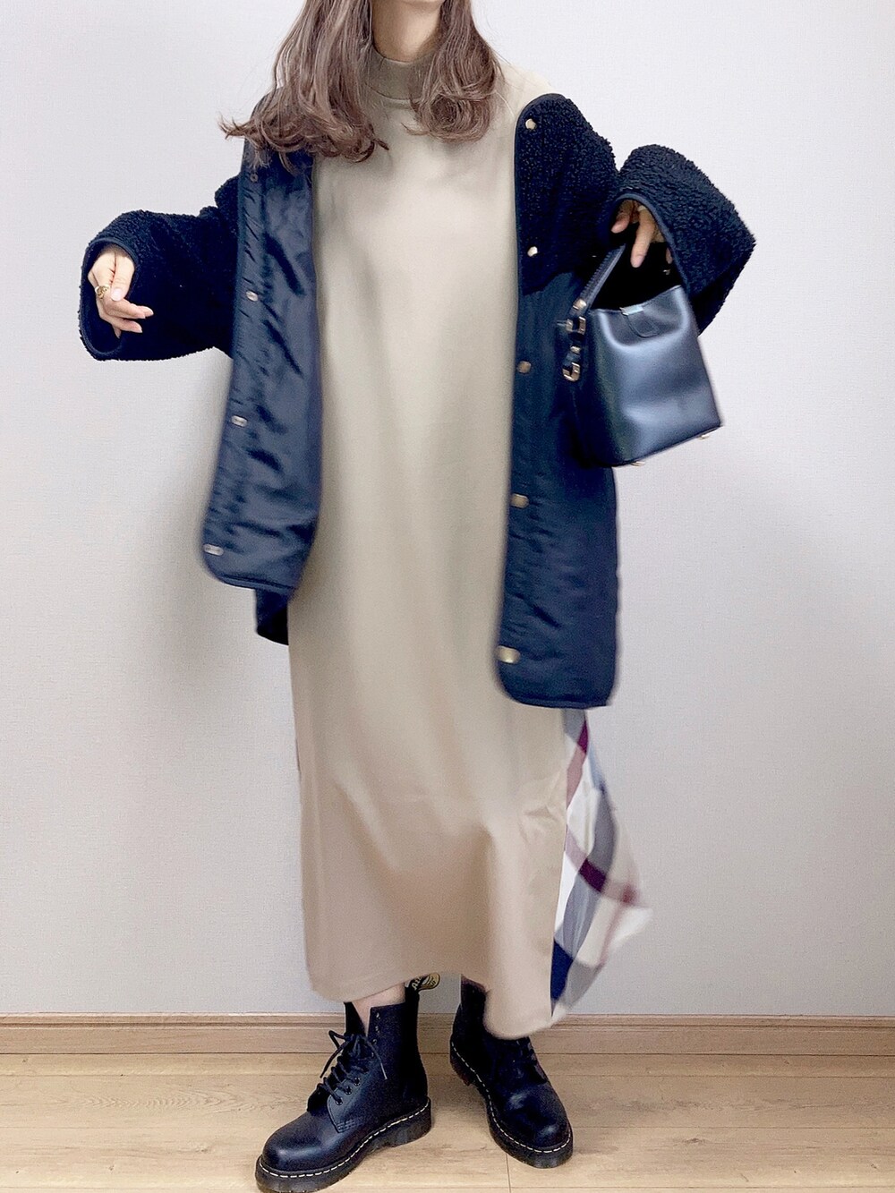 ベージュ系のワンピース、ブラック系のブルゾン、ブラック系のショルダーバッグを着用したレディースの冬コーディネートの2枚目の写真