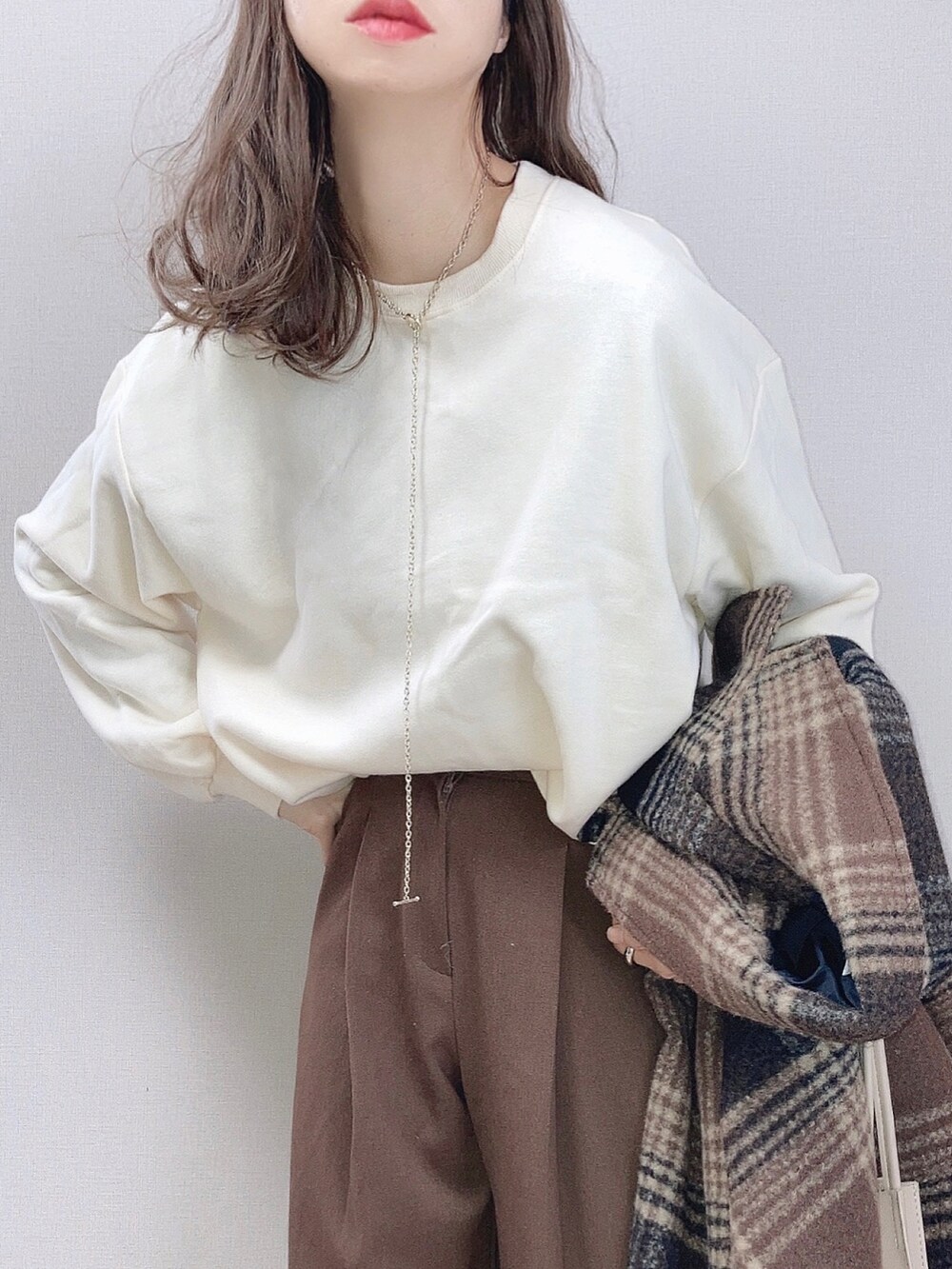 ホワイト系のスウェット、ブラウン系のその他パンツ、ベージュ系のスニーカーを着用したレディースの冬コーディネートの2枚目の写真