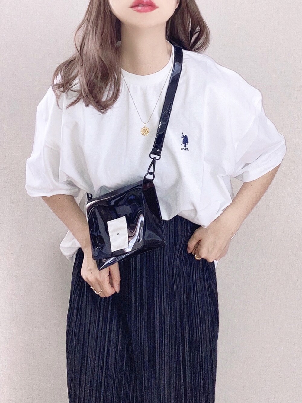 ホワイト系のTシャツ/カットソー、ブラック系のスカート、ブラック系のショルダーバッグを着用したレディースの春コーディネートの2枚目の写真