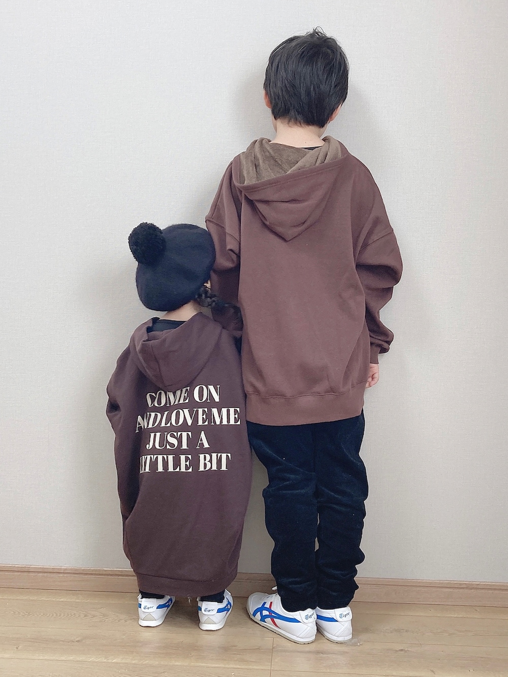 ホワイト系のスニーカー、ブラウン系のパーカー、ブラック系のその他パンツを着用したキッズの秋コーディネートの3枚目の写真