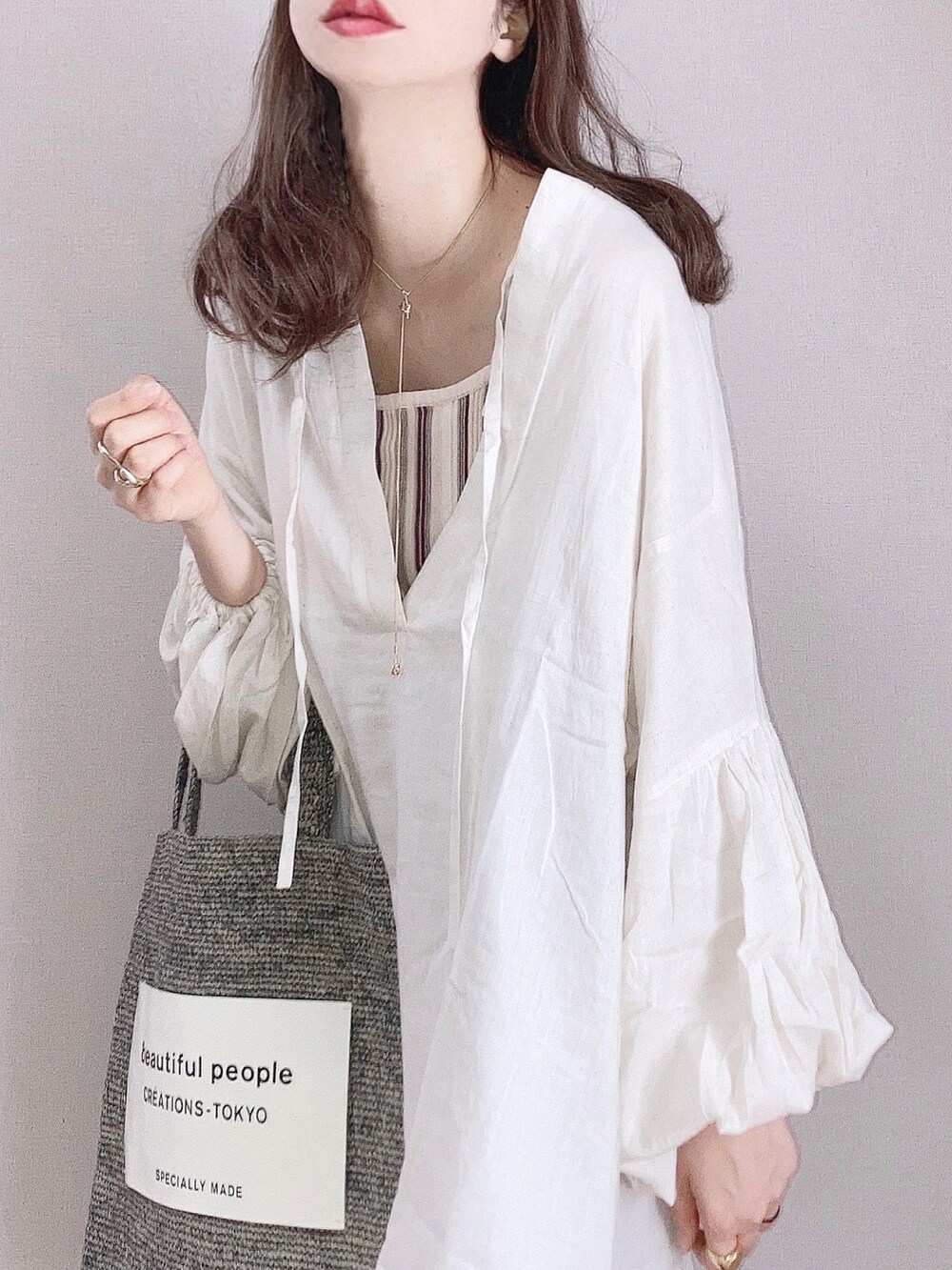 ベージュ系のシャツ/ブラウス、ブラウン系のその他パンツ、グレー系のトートバッグを着用したレディースの春コーディネートの3枚目の写真