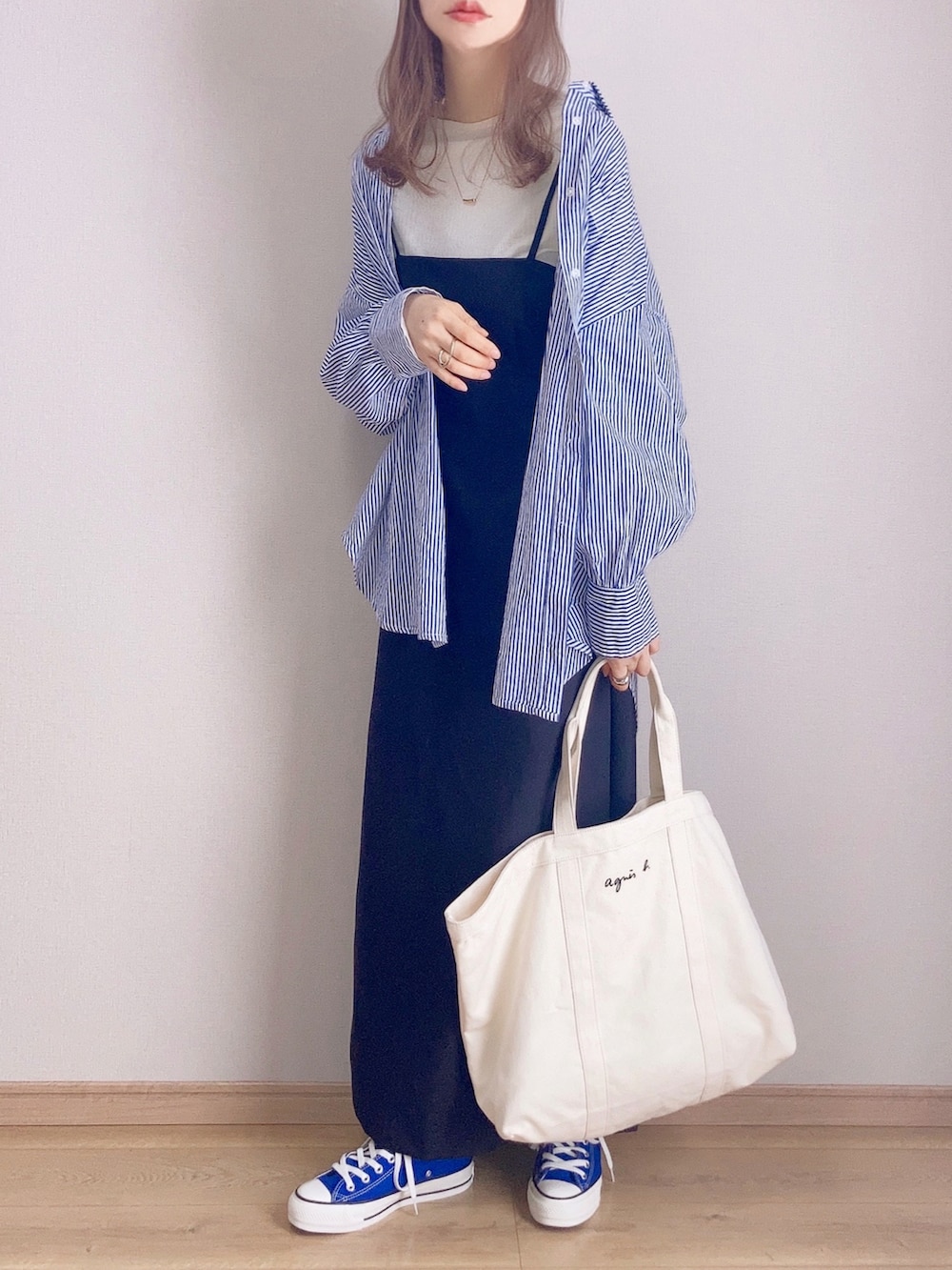 ブラック系のワンピース、ブルー系のシャツ/ブラウス、ホワイト系のTシャツ/カットソーを着用したレディースの春コーディネートの2枚目の写真