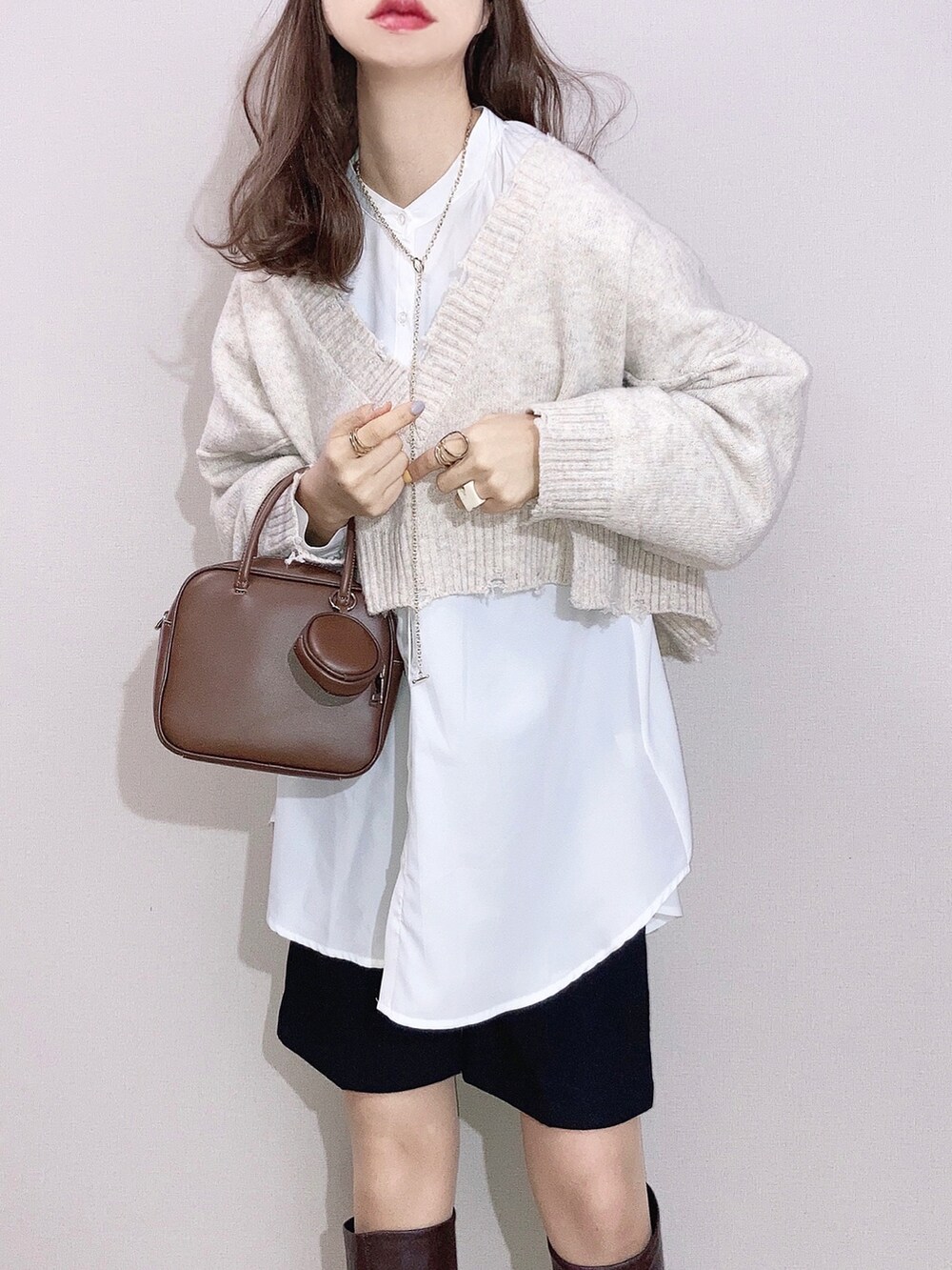 ホワイト系のニット/セーター、ホワイト系のシャツ/ブラウス、ブラック系のその他パンツを着用したレディースの冬コーディネートの2枚目の写真