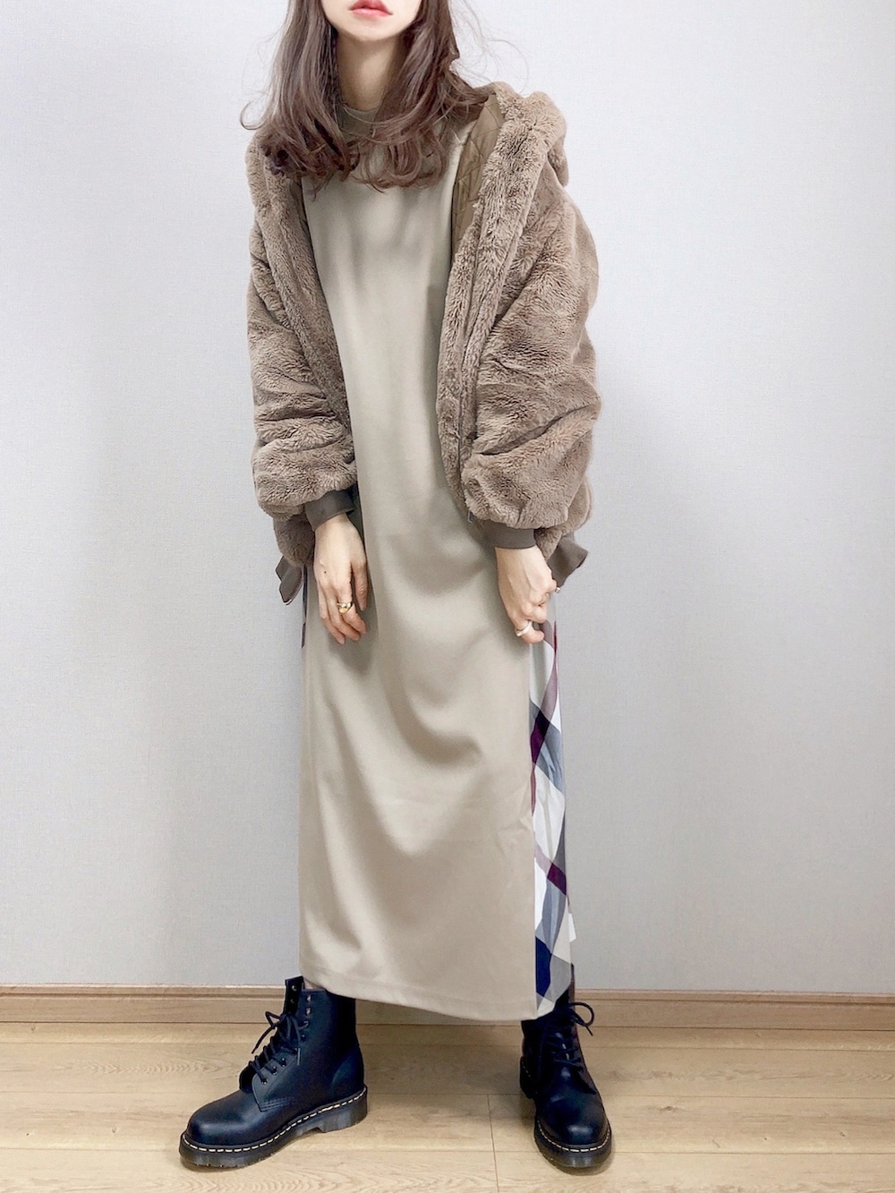 ベージュ系のワンピース、ブラウン系のブルゾン、ブラック系のブーツを着用したレディースの冬コーディネートの2枚目の写真