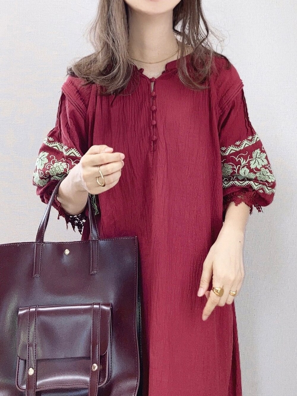 ブラウン系のブーツ、レッド系のワンピース、ブラウン系のハンドバッグを着用したレディースの夏コーディネートの2枚目の写真