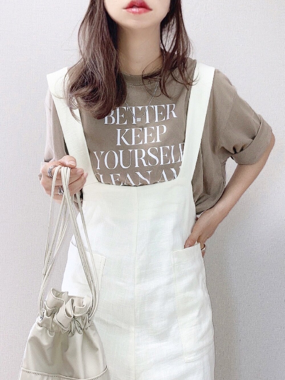 ベージュ系のTシャツ/カットソー、ホワイト系のサロペット/オーバーオール、ベージュ系のショルダーバッグを着用したレディースの夏コーディネートの2枚目の写真