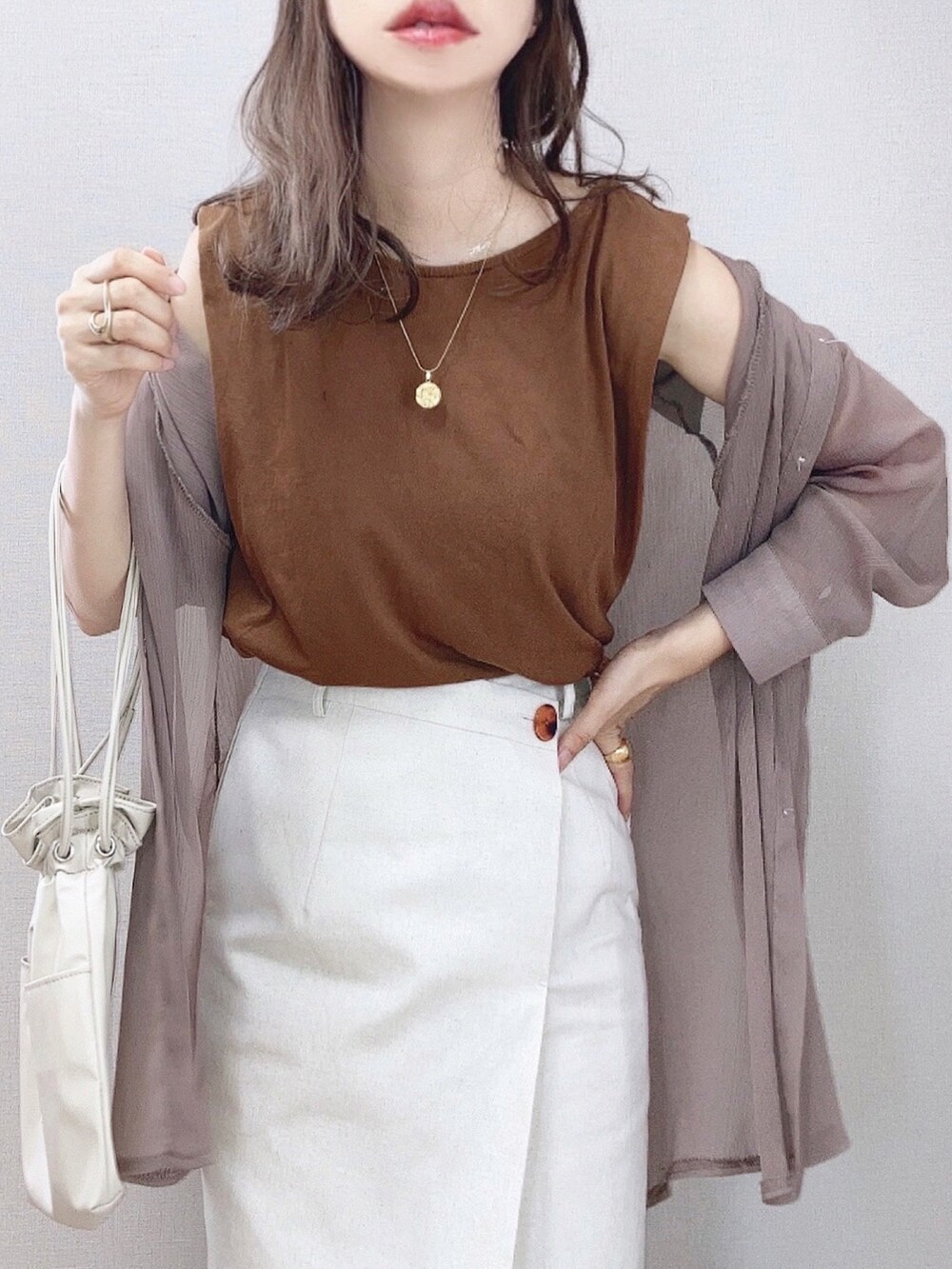 ベージュ系のスカート、ブラウン系のタンクトップ、ベージュ系のシャツ/ブラウスを着用したレディースの夏コーディネートの2枚目の写真