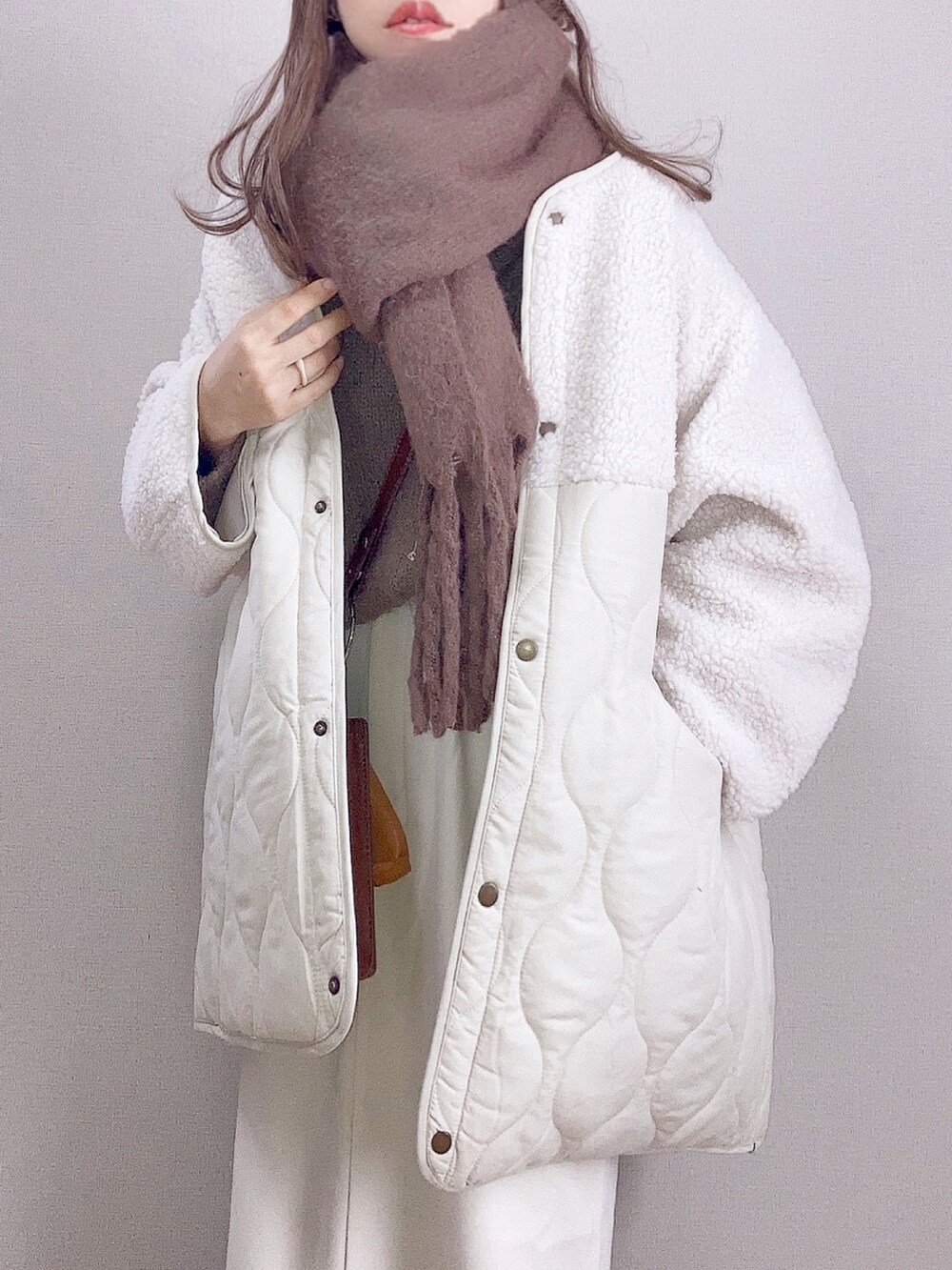 ホワイト系のブルゾン、ホワイト系のスカート、ブラウン系のショルダーバッグを着用したレディースの秋コーディネートの3枚目の写真