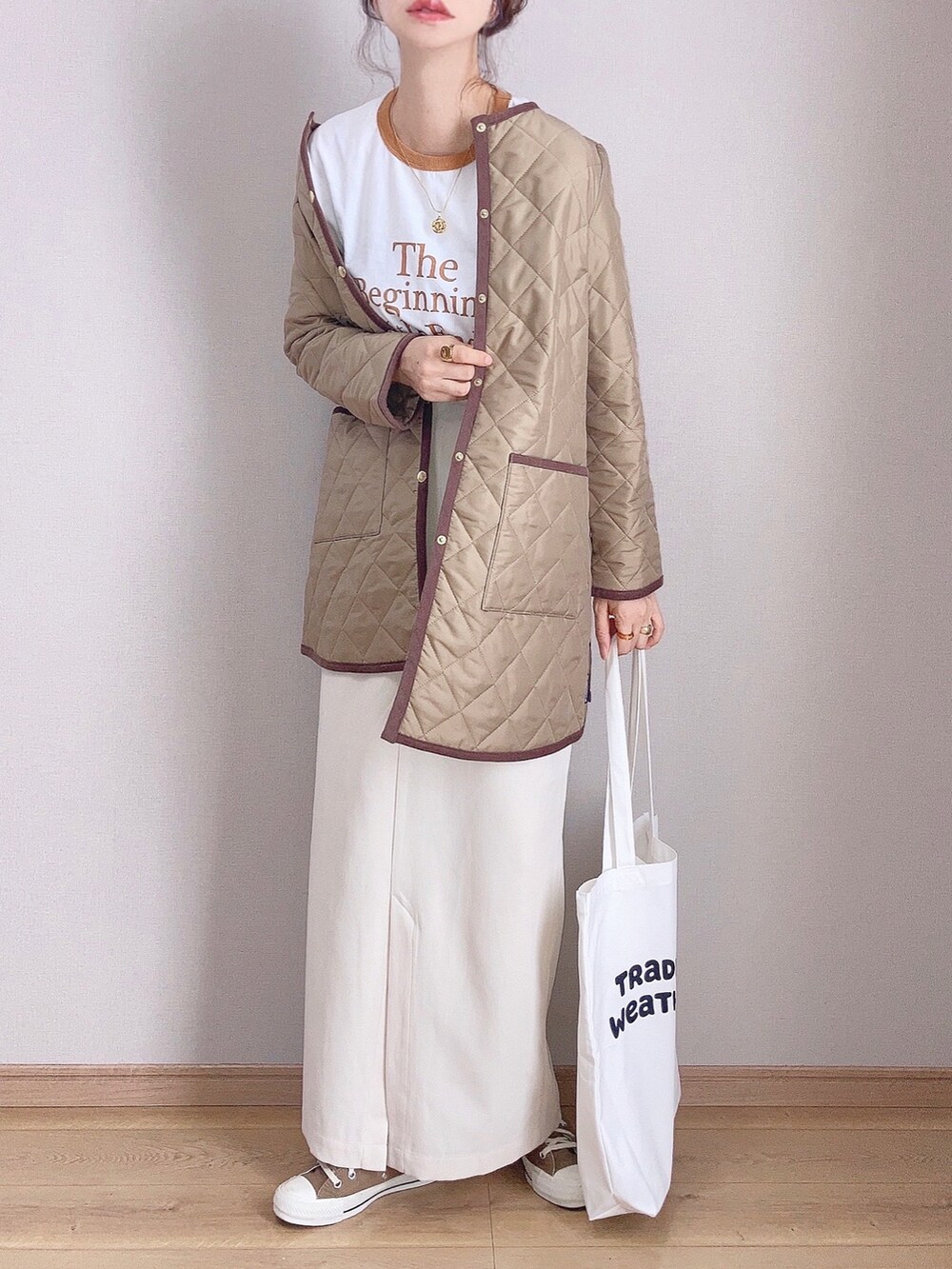 ベージュ系のその他アウター、イエロー系のTシャツ/カットソー、ホワイト系のスカートを着用したレディースの秋コーディネートの2枚目の写真