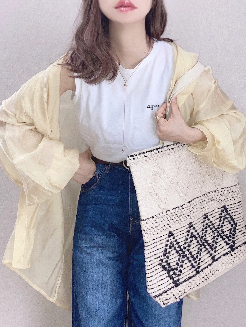 ホワイト系のTシャツ/カットソー、イエロー系のシャツ/ブラウス、ベージュ系のトートバッグを着用したレディースの春コーディネートの2枚目の写真