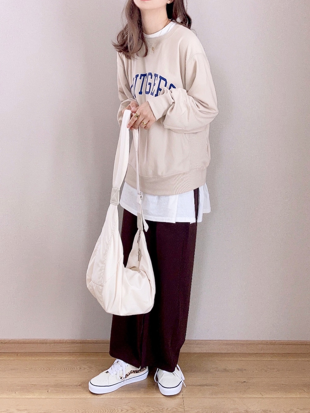 ホワイト系のスウェット、ブラウン系のスカート、ホワイト系のショルダーバッグを着用したレディースの秋コーディネートの2枚目の写真