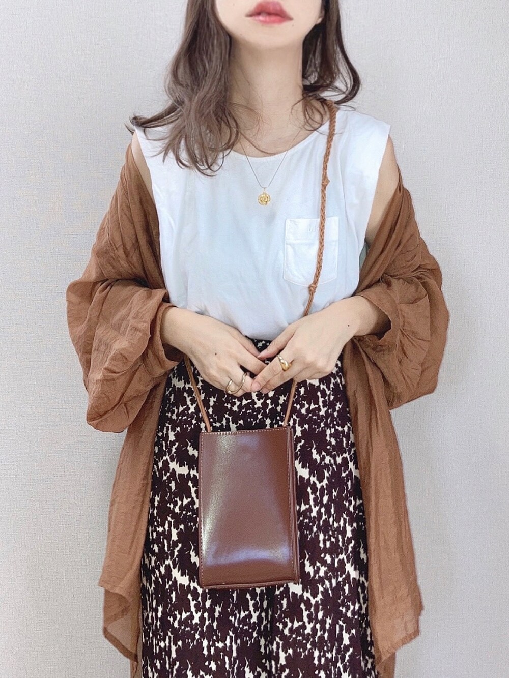 ホワイト系のTシャツ/カットソー、ブラウン系のシャツ/ブラウス、ホワイト系のスカートを着用したレディースの夏コーディネートの2枚目の写真