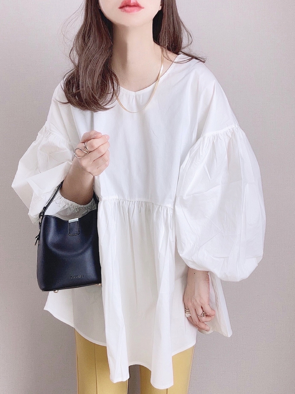 ホワイト系のシャツ/ブラウス、イエロー系のその他パンツ、ブラック系のショルダーバッグを着用したレディースの春コーディネートの2枚目の写真