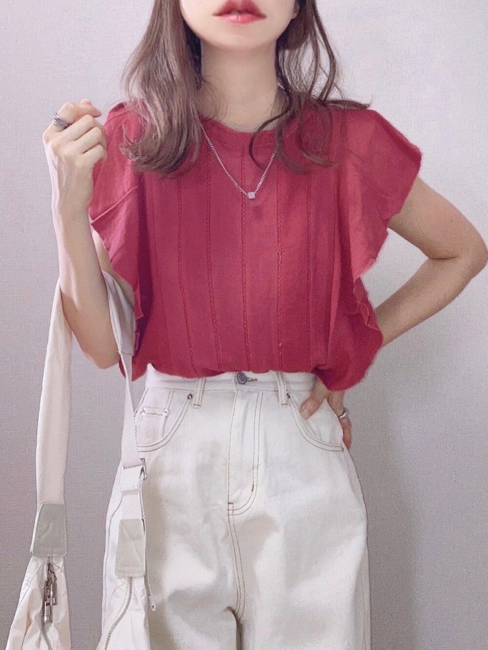 ピンク系のシャツ/ブラウス、ホワイト系のショルダーバッグ、ベージュ系のデニムパンツを着用したレディースの夏コーディネートの2枚目の写真