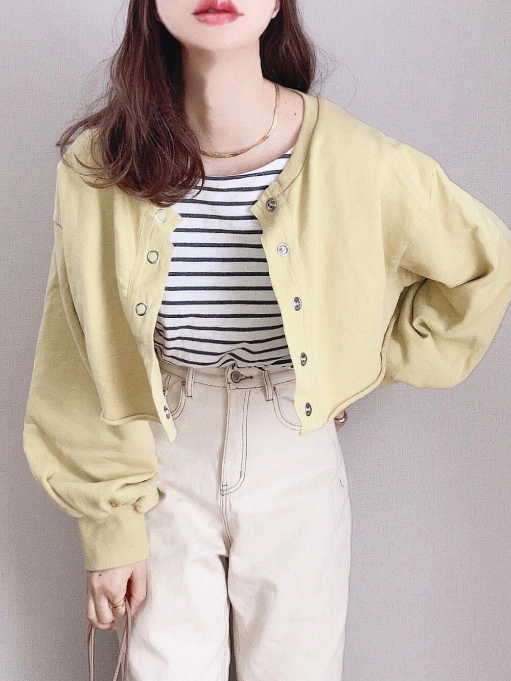 イエロー系のスウェット、ブラック系のTシャツ/カットソー、ベージュ系のデニムパンツを着用したレディースの春コーディネートの2枚目の写真