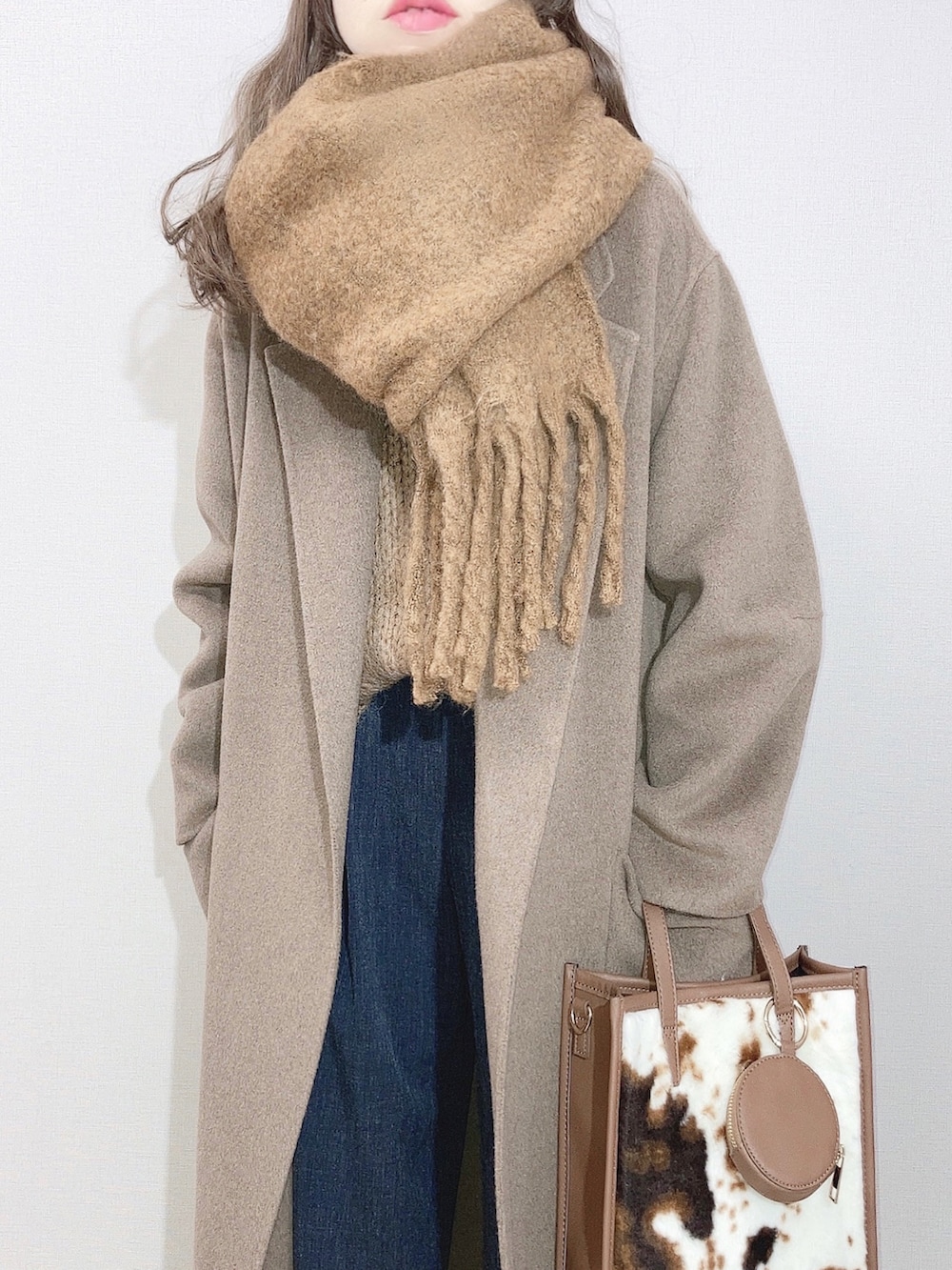 ブラウン系のピーコート、ブラウン系のニット/セーター、グレー系のその他パンツを着用したレディースの冬コーディネートの2枚目の写真