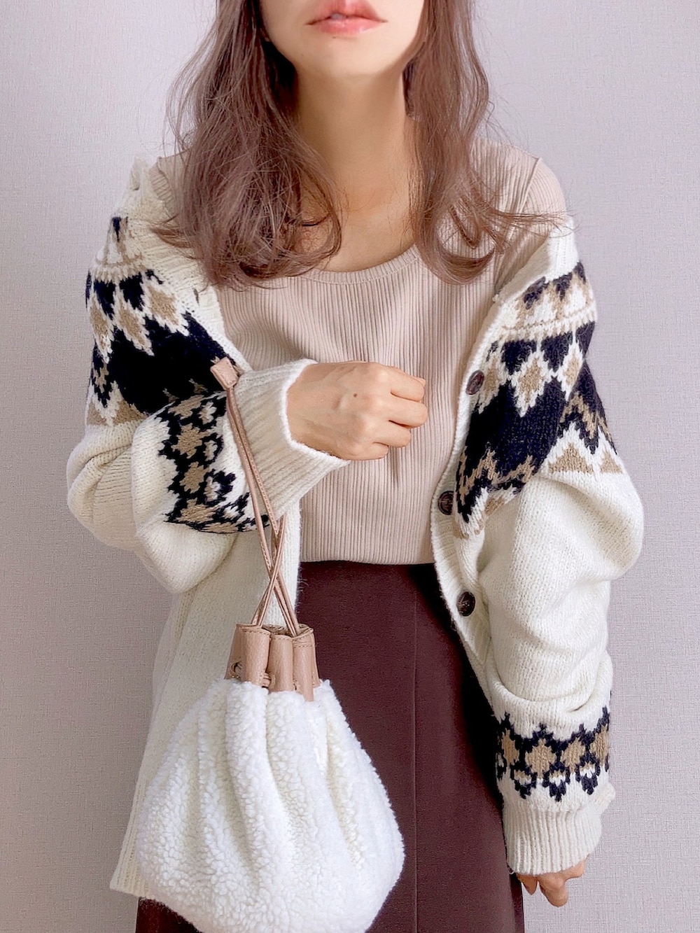 ベージュ系のTシャツ/カットソー、ブラウン系のスカート、ホワイト系のニット/セーターを着用したレディースの秋コーディネートの2枚目の写真