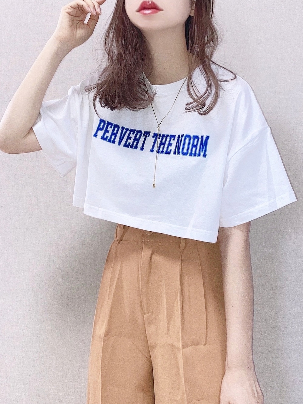 ホワイト系のTシャツ/カットソー、イエロー系のスラックス、ブラック系のショルダーバッグを着用したレディースの春コーディネートの2枚目の写真