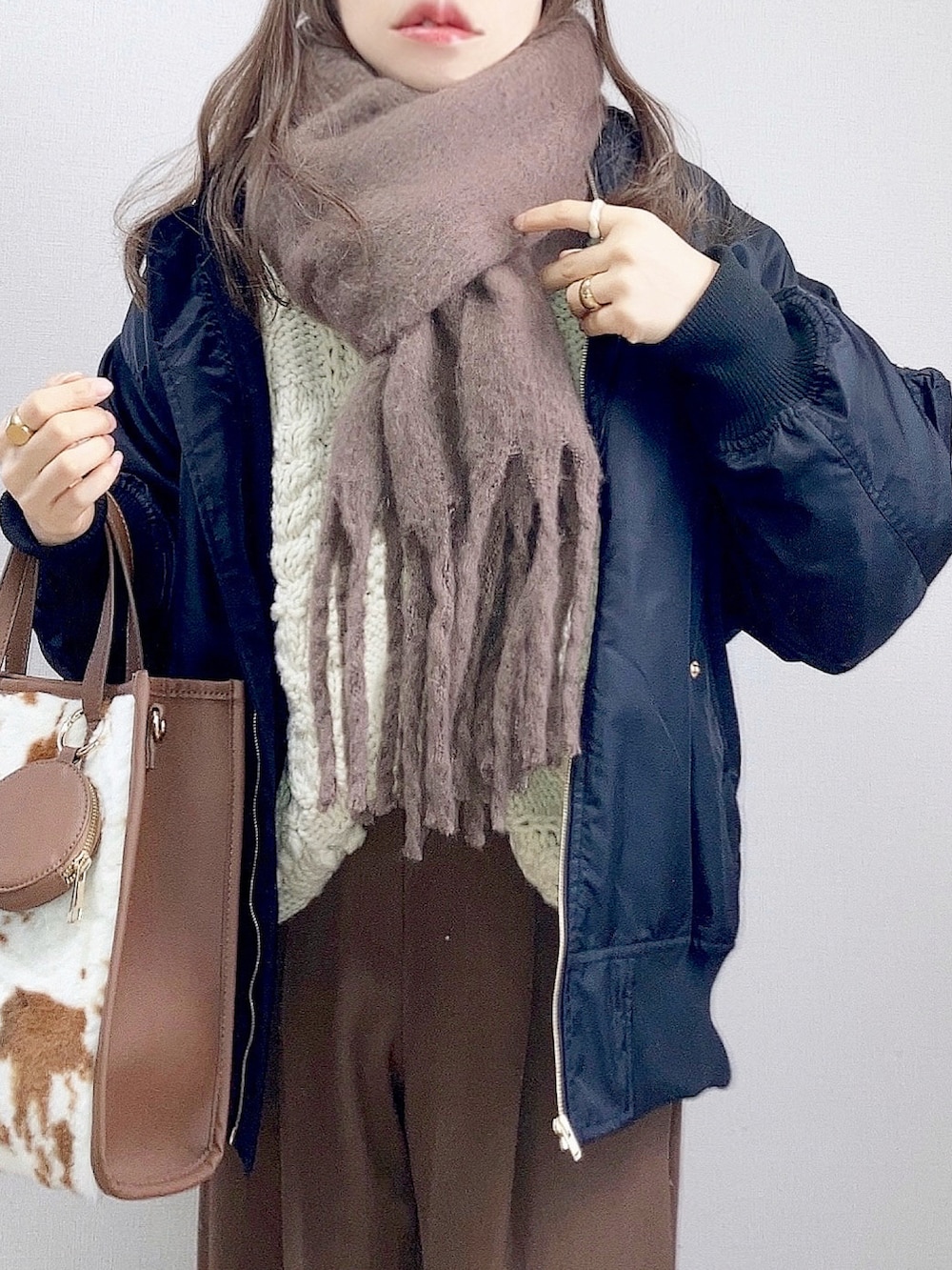 ブラック系のブルゾン、ホワイト系のニット/セーター、ブラウン系のその他パンツを着用したレディースの冬コーディネートの2枚目の写真