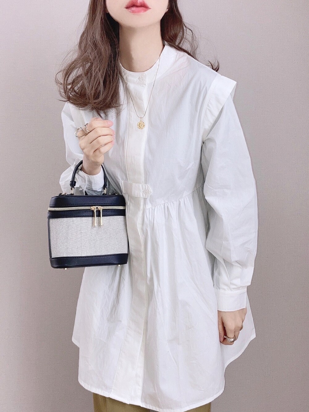 ホワイト系のシャツ/ブラウス、グリーン系のスラックス、ブラック系のバッグを着用したレディースの冬コーディネートの2枚目の写真