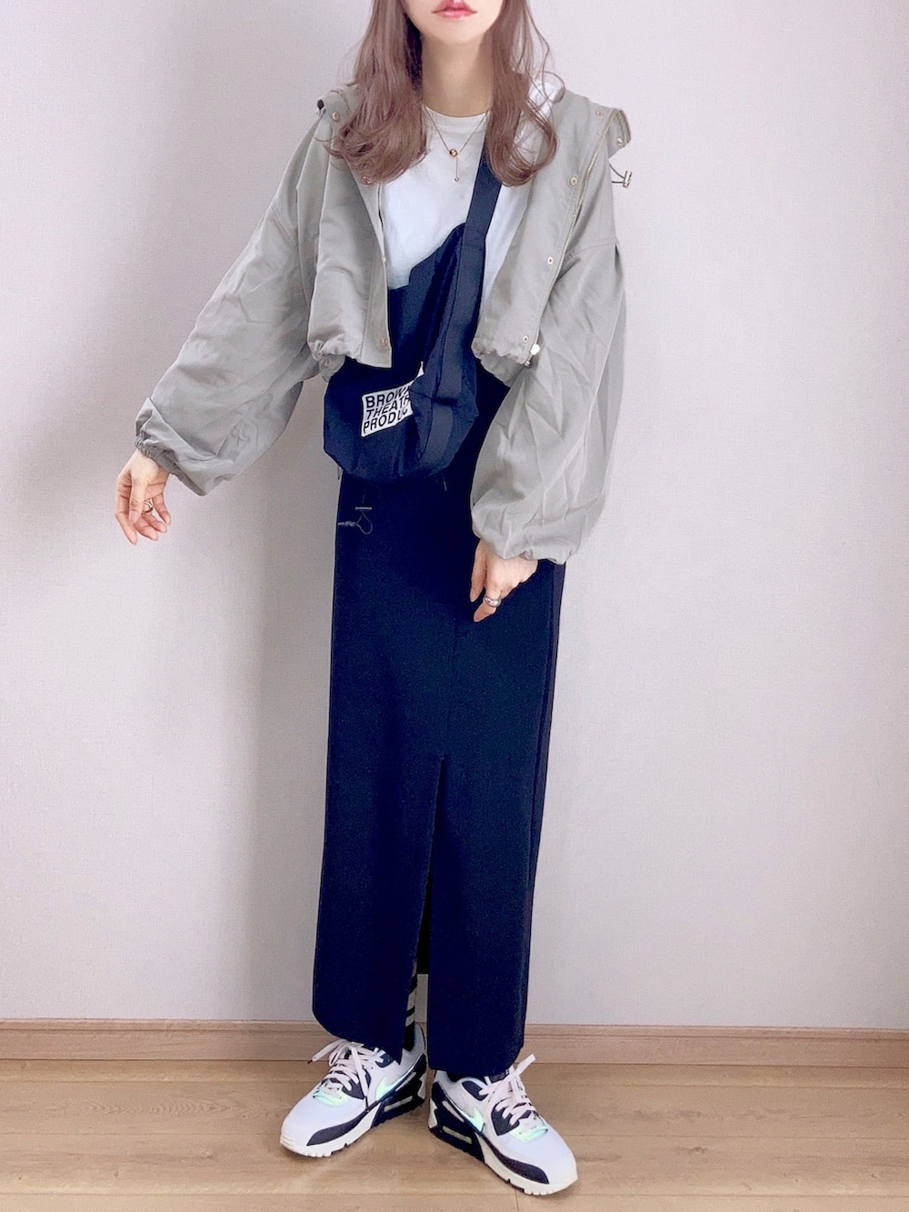 グリーン系のマウンテンパーカー、ブラック系のスカート、ブラック系のショルダーバッグを着用したレディースの春コーディネートの3枚目の写真