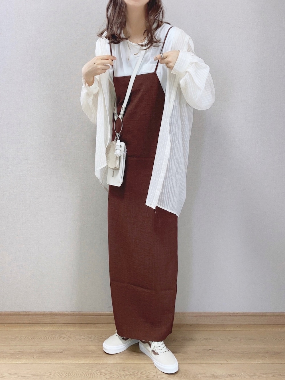 ブラウン系のワンピース、ホワイト系のシャツ/ブラウス、ホワイト系のショルダーバッグを着用したレディースの春コーディネートの2枚目の写真