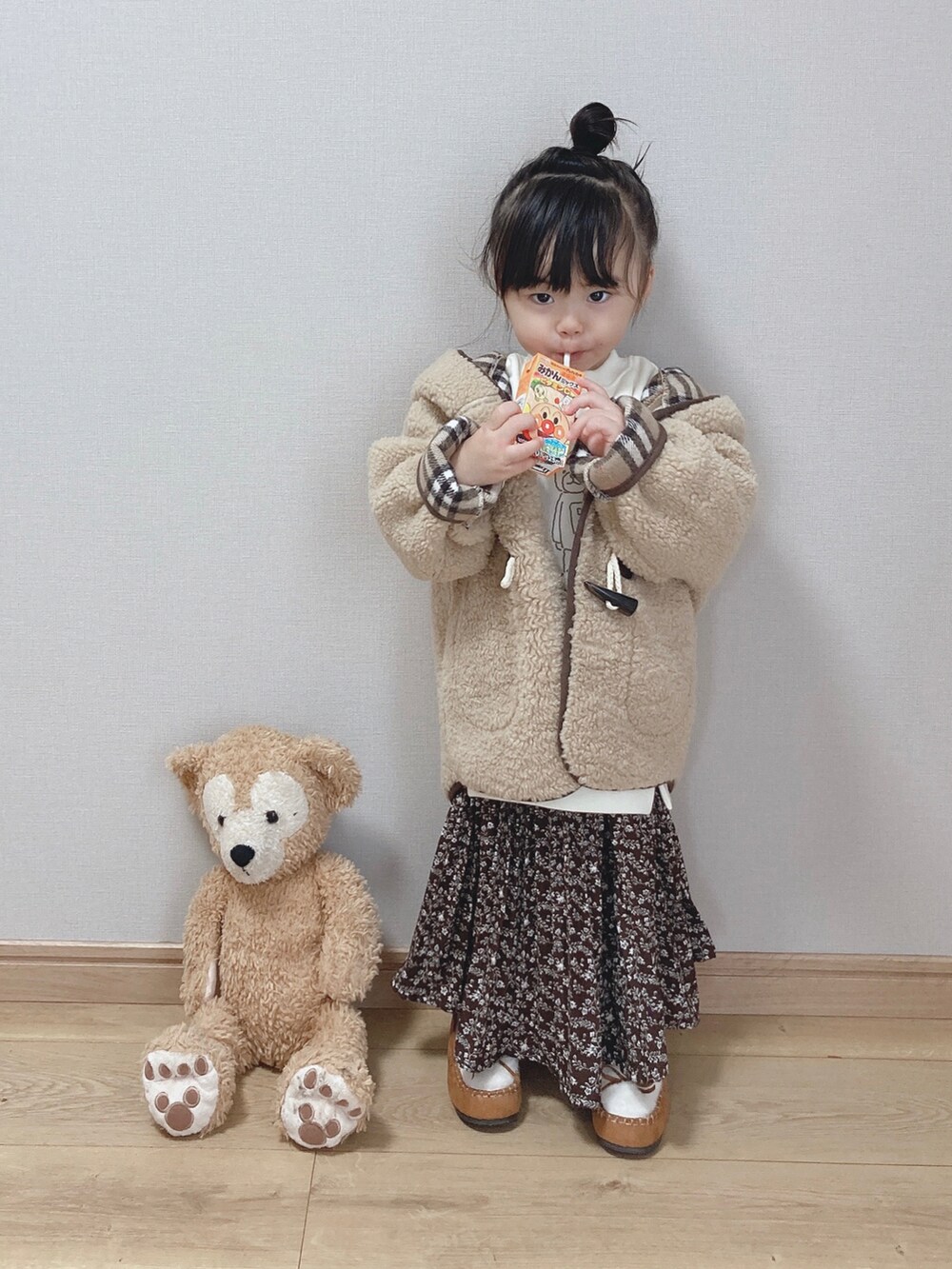 ベージュ系のダッフルコート、ホワイト系のスウェット、ブラウン系のその他パンツを着用したキッズの秋コーディネートの3枚目の写真