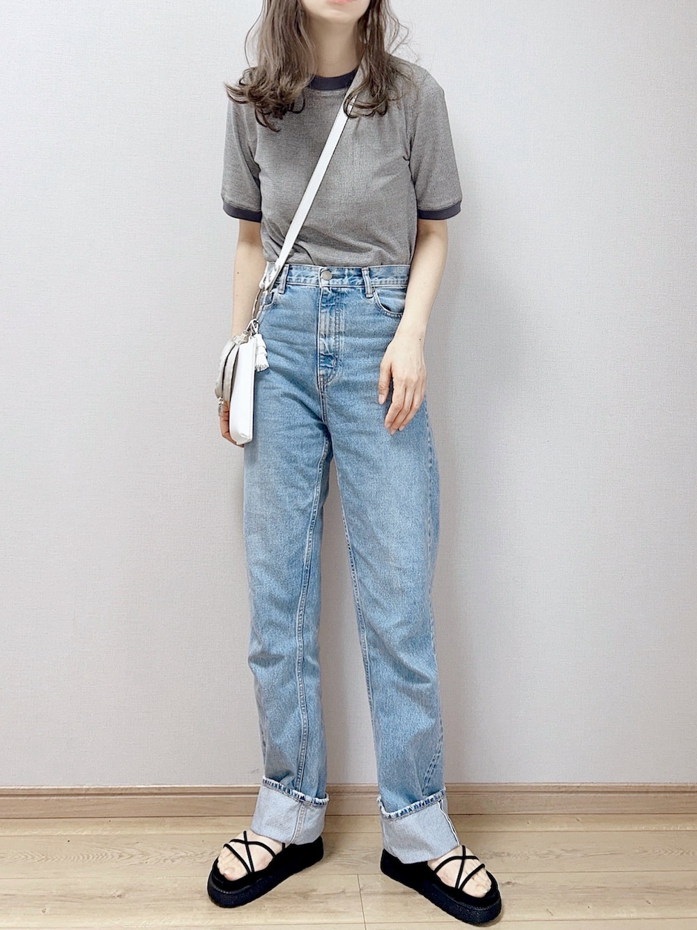 ブラック系のTシャツ/カットソー、ホワイト系のショルダーバッグ、ブラック系のサンダルを着用したレディースの春コーディネートの2枚目の写真