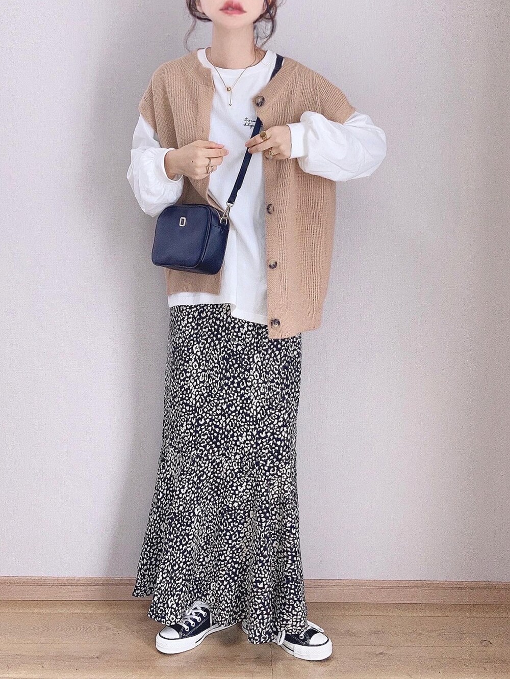ベージュ系のカーディガン/ボレロ、ホワイト系のTシャツ/カットソー、ブラック系のスカートを着用したレディースの秋コーディネートの2枚目の写真