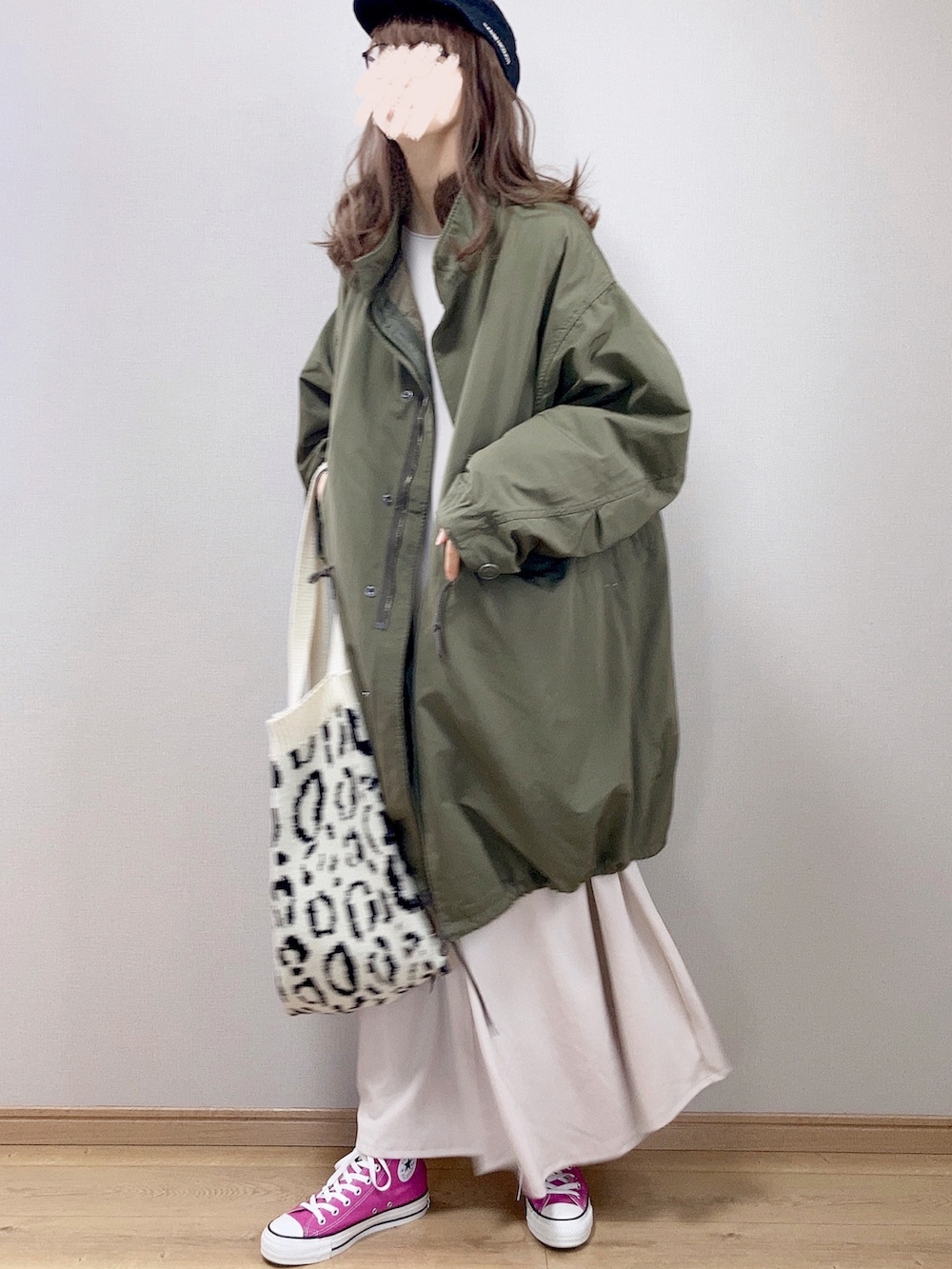 グリーン系のモッズコート、ベージュ系のワンピース、ホワイト系のトートバッグを着用したレディースの冬コーディネートの3枚目の写真