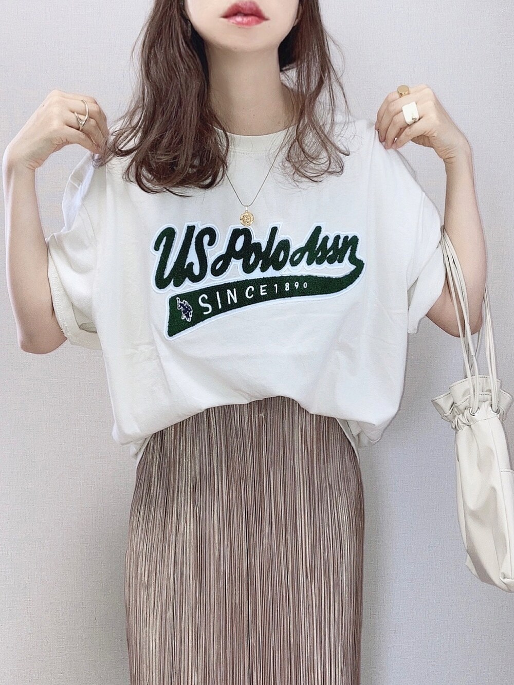 ベージュ系のTシャツ/カットソー、ブラウン系のスカート、ベージュ系のショルダーバッグを着用したレディースの夏コーディネートの2枚目の写真