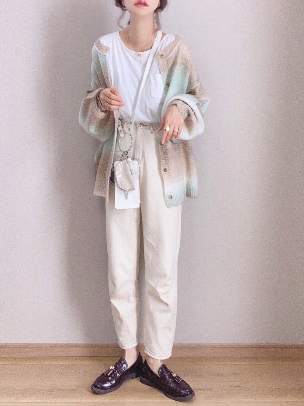 グリーン系のカーディガン/ボレロ、ベージュ系のデニムパンツ、ブラウン系のローファーを着用したレディースの秋コーディネートの3枚目の写真