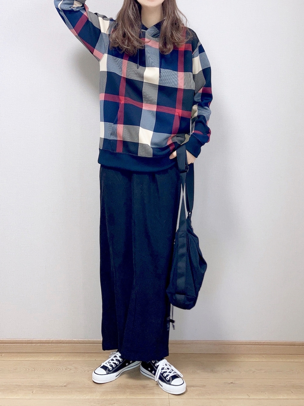 ブルー系のパーカー、ブラック系のスカート、ブラック系のショルダーバッグを着用したレディースの冬コーディネートの2枚目の写真