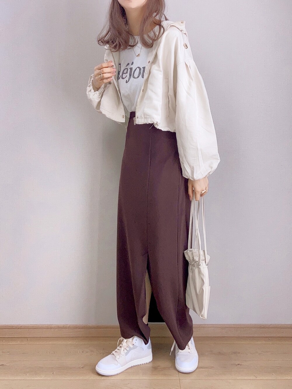ホワイト系のマウンテンパーカー、ホワイト系のTシャツ/カットソー、ブラウン系のスカートを着用したレディースの春コーディネートの4枚目の写真