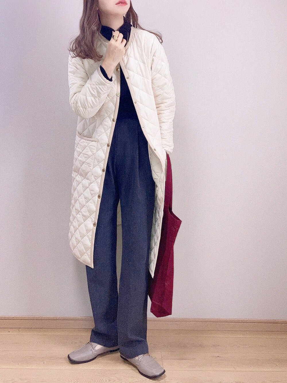 ホワイト系のその他アウター、レッド系のトートバッグ、ブラック系のニット/セーターを着用したレディースの秋コーディネートの2枚目の写真