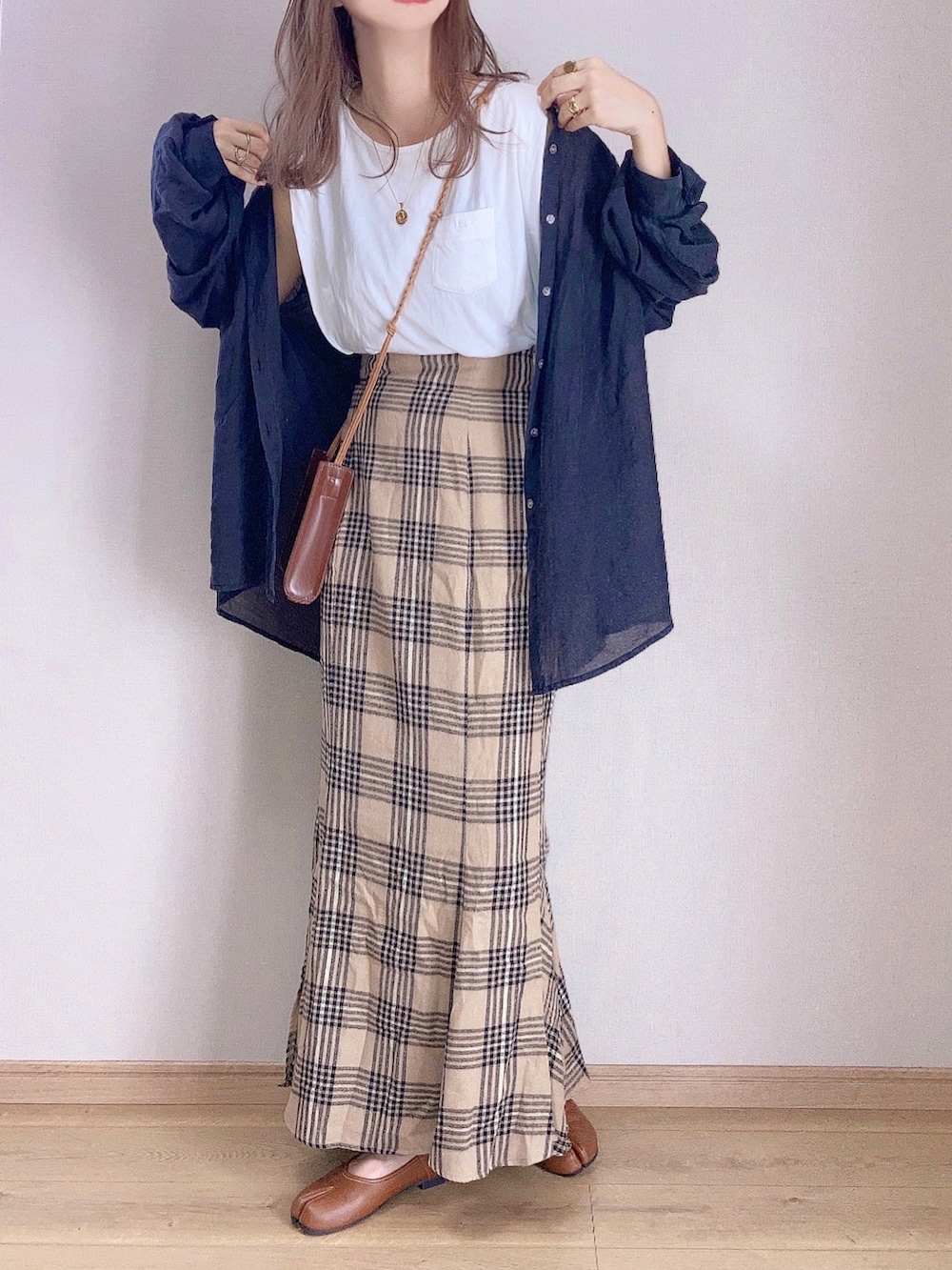 ブラウン系のスカート、ブラック系のシャツ/ブラウス、ブラウン系のショルダーバッグを着用したレディースの秋コーディネートの2枚目の写真