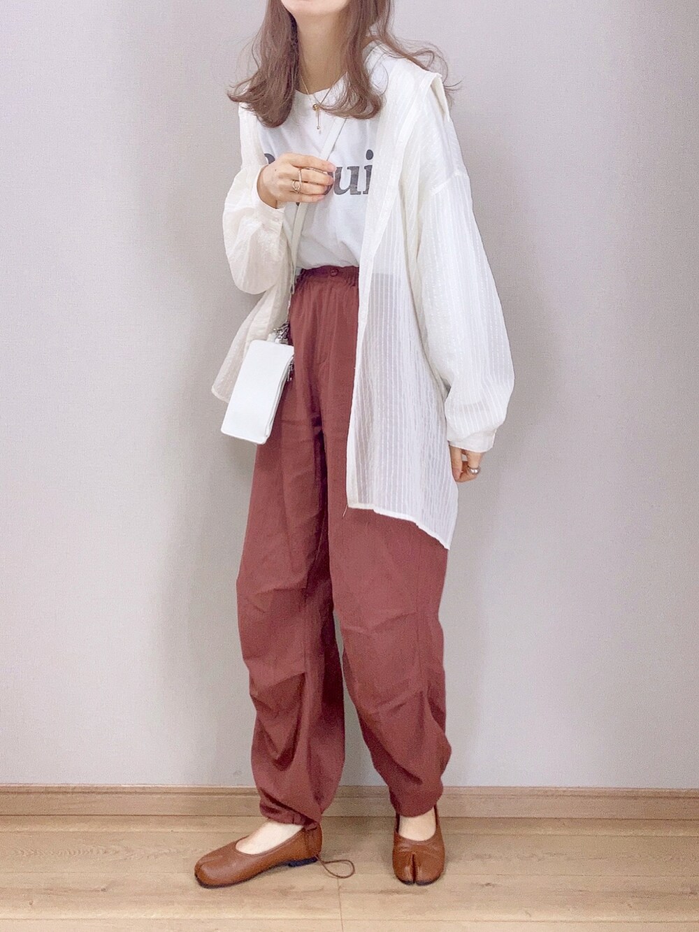 ブラウン系のカーゴパンツ、ホワイト系のシャツ/ブラウス、ホワイト系のTシャツ/カットソーを着用したレディースの春コーディネートの2枚目の写真