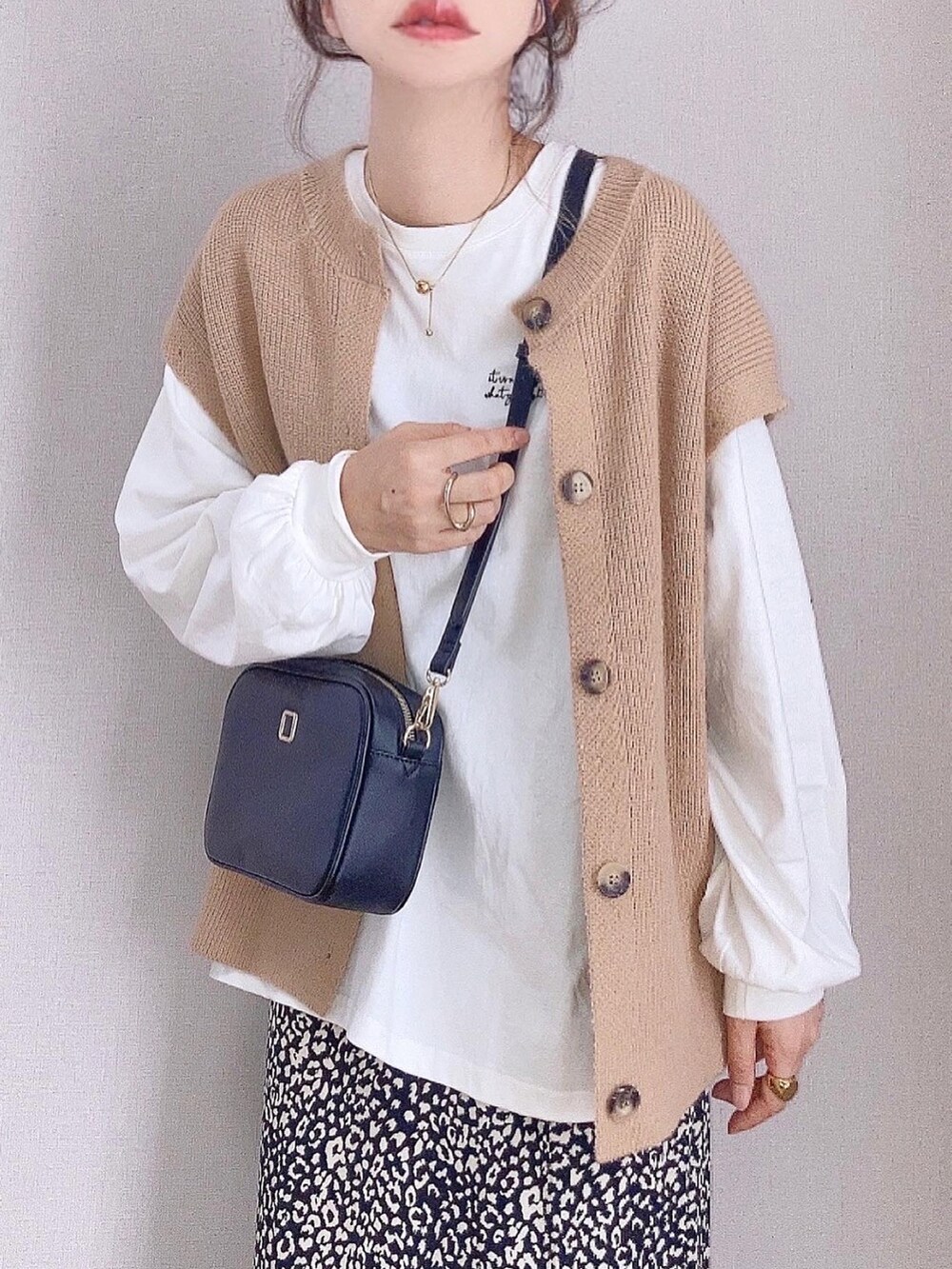 ベージュ系のカーディガン/ボレロ、ホワイト系のTシャツ/カットソー、ブラック系のスカートを着用したレディースの秋コーディネートの3枚目の写真