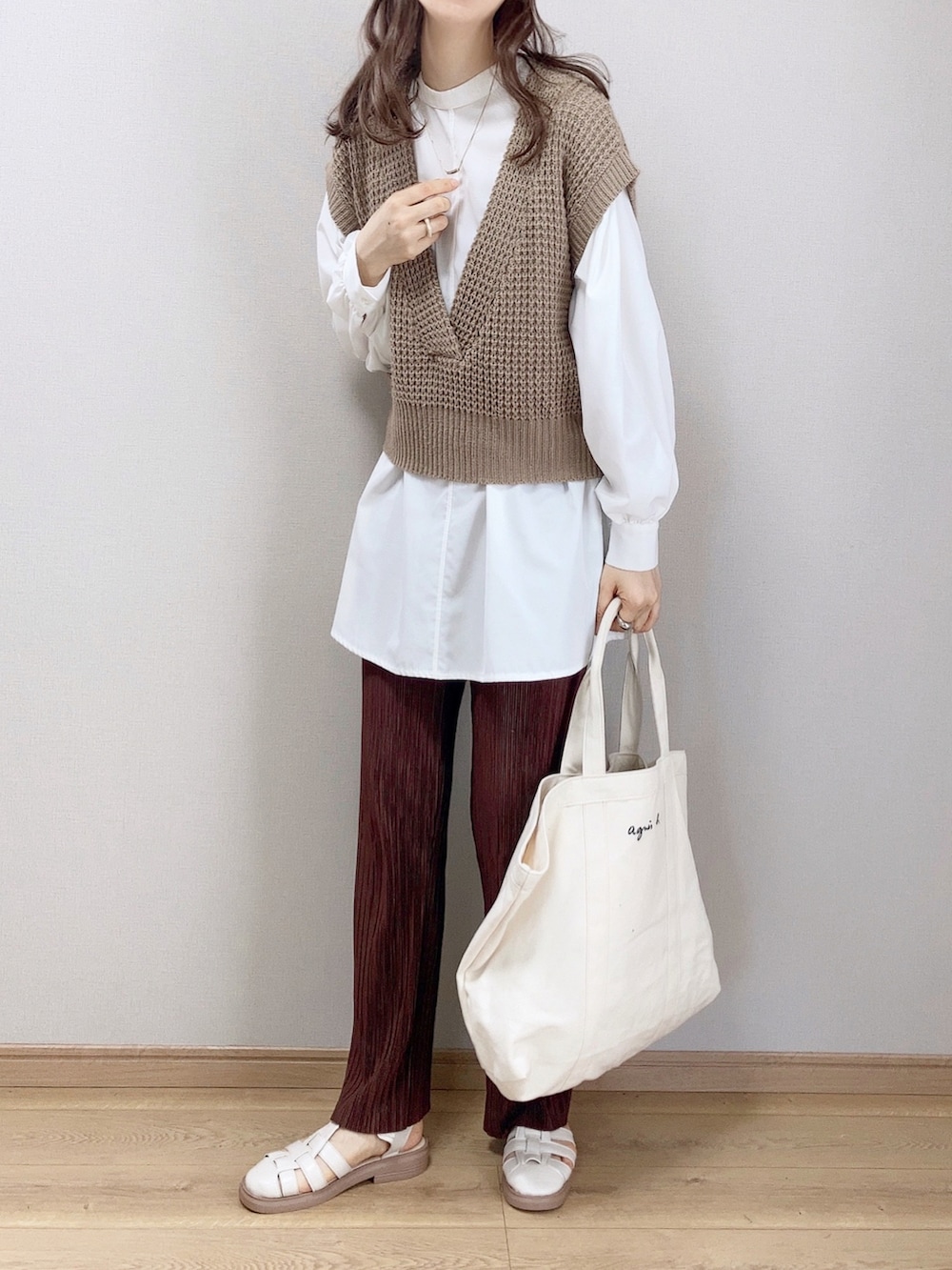 ブラウン系のベスト、ブラウン系のその他パンツ、ベージュ系のトートバッグを着用したレディースの春コーディネートの2枚目の写真