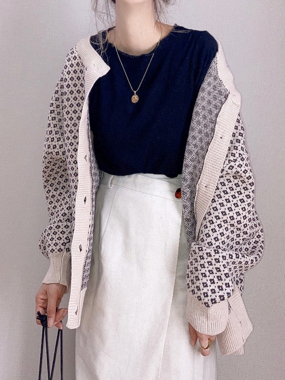 ベージュ系のカーディガン/ボレロ、ベージュ系のスカート、ベージュ系のショルダーバッグを着用したレディースの秋コーディネートの4枚目の写真