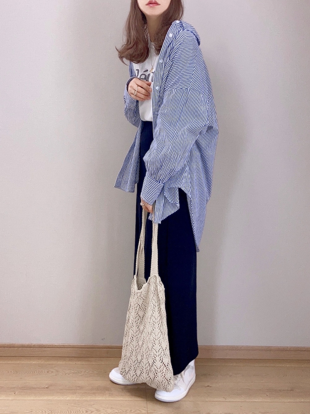 ブルー系のシャツ/ブラウス、ホワイト系のTシャツ/カットソー、ブラック系のスカートを着用したレディースの春コーディネートの3枚目の写真