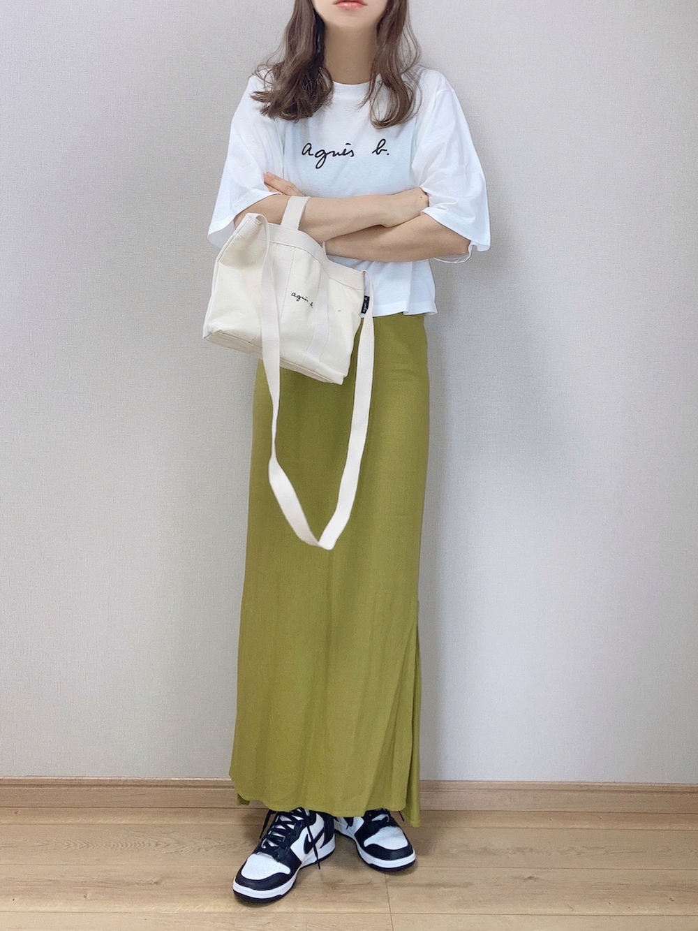 ホワイト系のTシャツ/カットソー、ホワイト系のトートバッグ、グリーン系のスカートを着用したレディースの春コーディネートの2枚目の写真