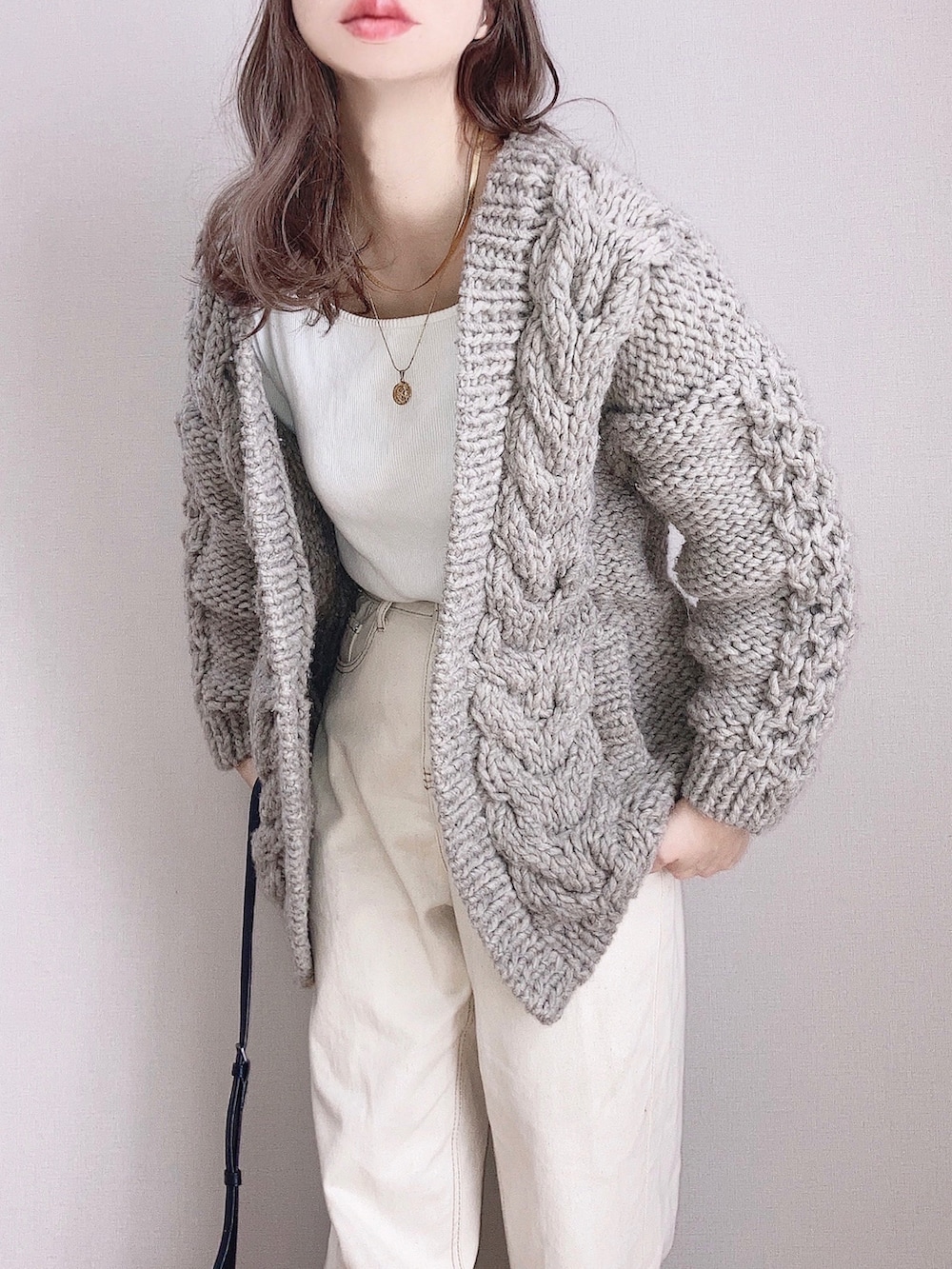 グレー系のカーディガン/ボレロ、ホワイト系のTシャツ/カットソー、ベージュ系のデニムパンツを着用したレディースの冬コーディネートの2枚目の写真